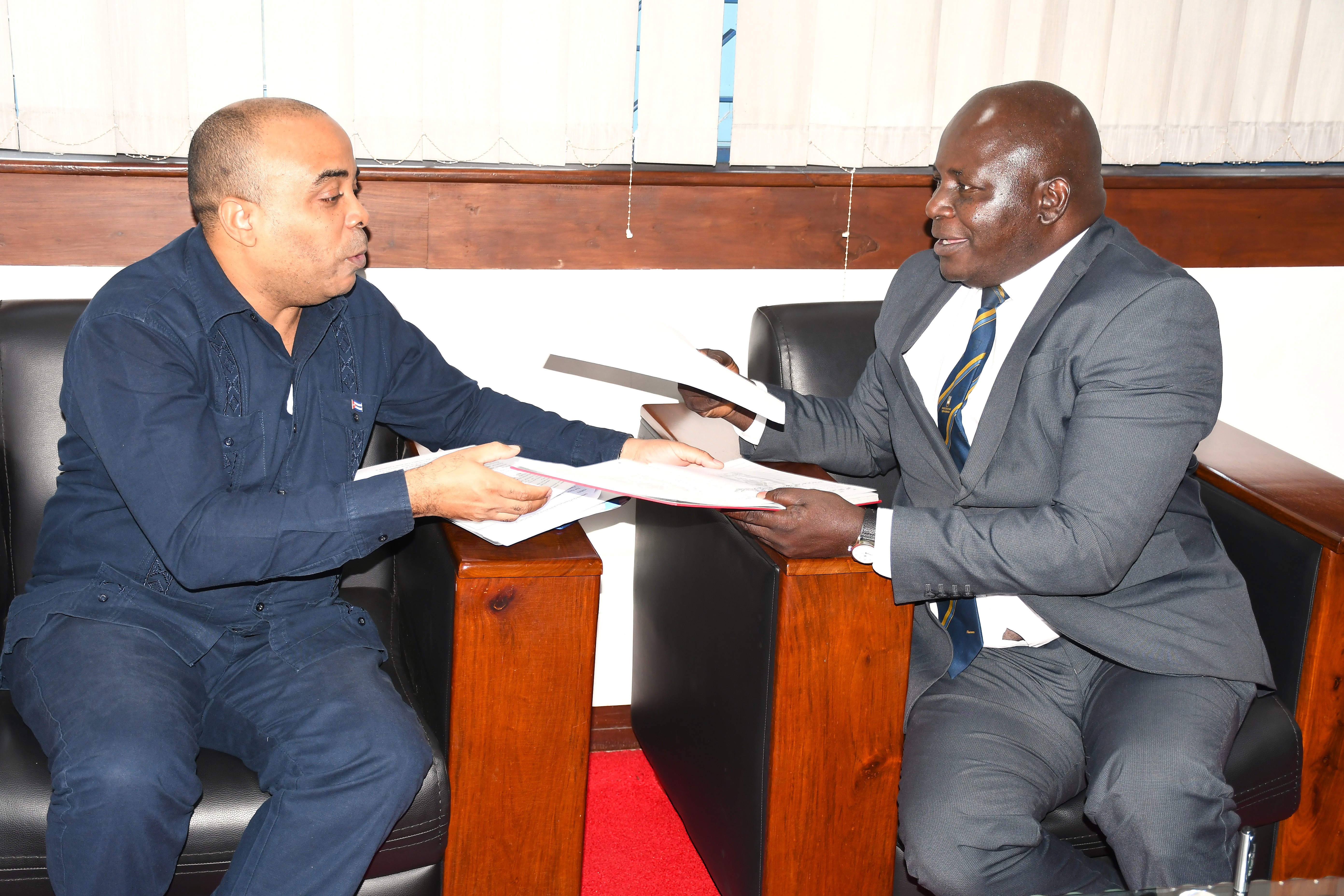Balozi wa Jamuhuri ya Cuba Mheshimiwa Yordenis Despaigne Vera (kulia) akikabidhi hati ya Mashirikiano ya Utendaji kazi kwa Mkurugenzi wa Utawala,Fedha na Mipango  Dkt.Jacob Nduye, alipotembel